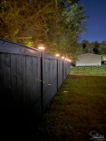 a view of a yard with wooden fence
