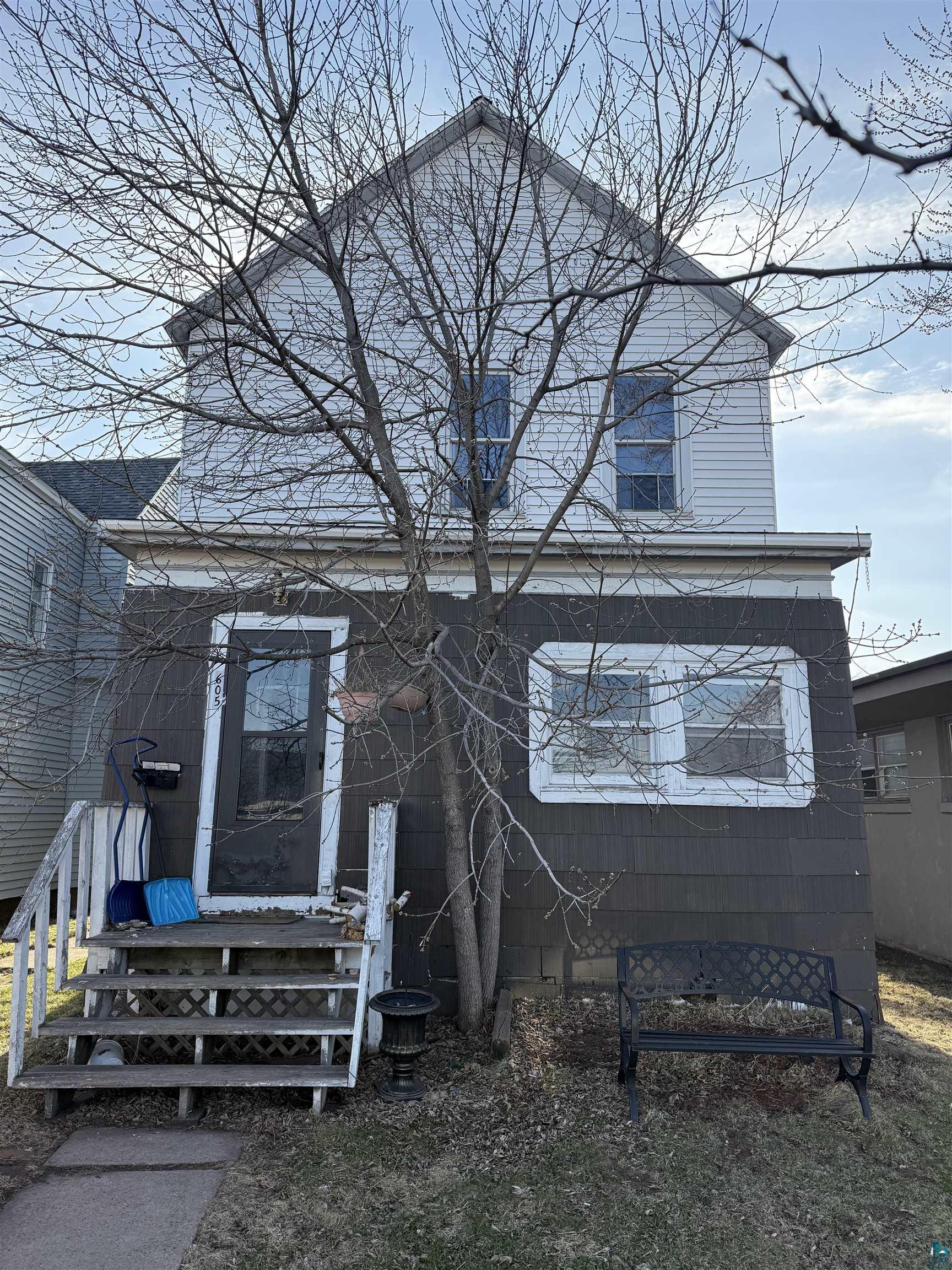 Two-story exterior with horizontal siding on the upper level and shingle siding on the lower level