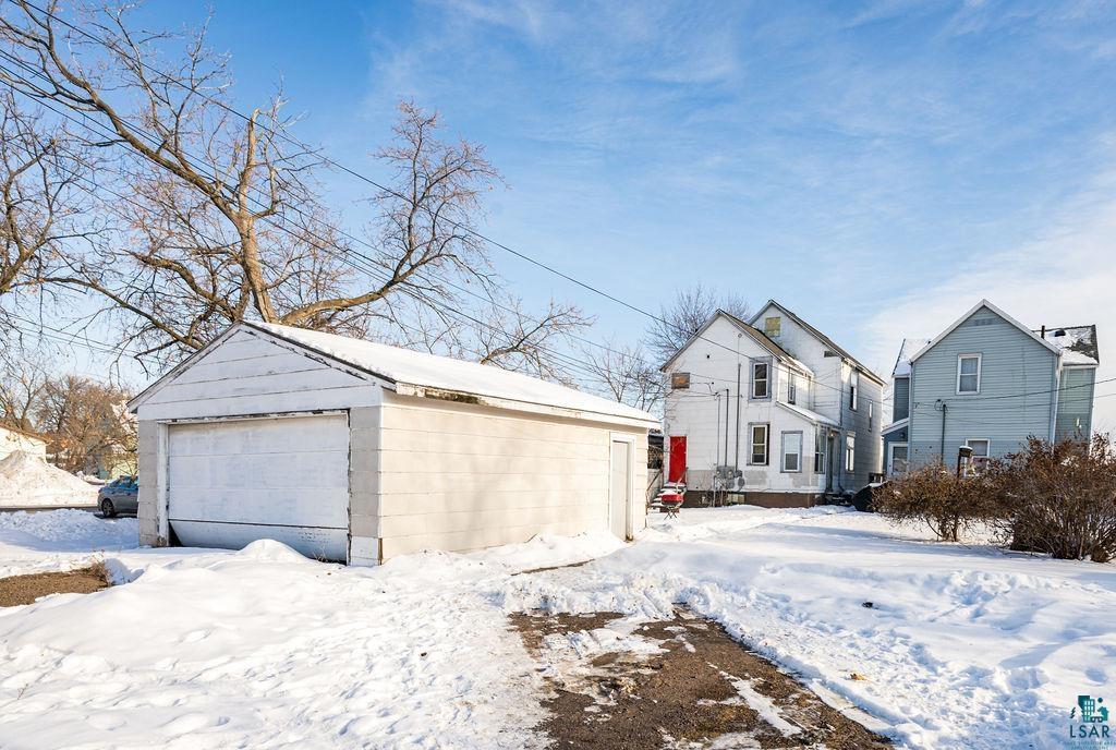605 Weeks Avenue Superior, WI 54880 - Photo 19 of 21 View of snow covered exterior featuring an outbuilding and a garage