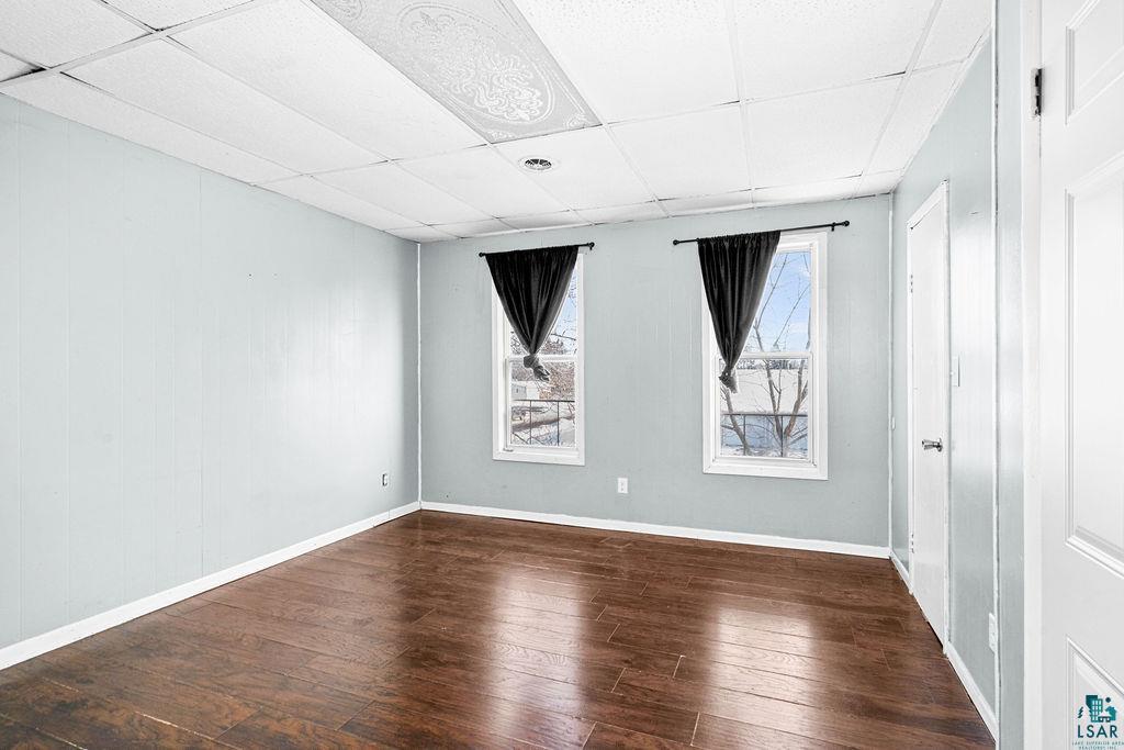605 Weeks Avenue Superior, WI 54880 - Photo 5 of 21 Spare room with a paneled ceiling and dark wood-style flooring