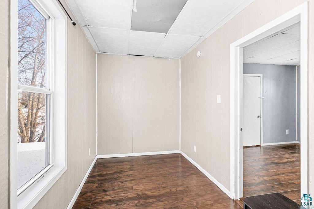 605 Weeks Avenue Superior, WI 54880 - Photo 9 of 21 Spare room with dark wood finished floors and a paneled ceiling