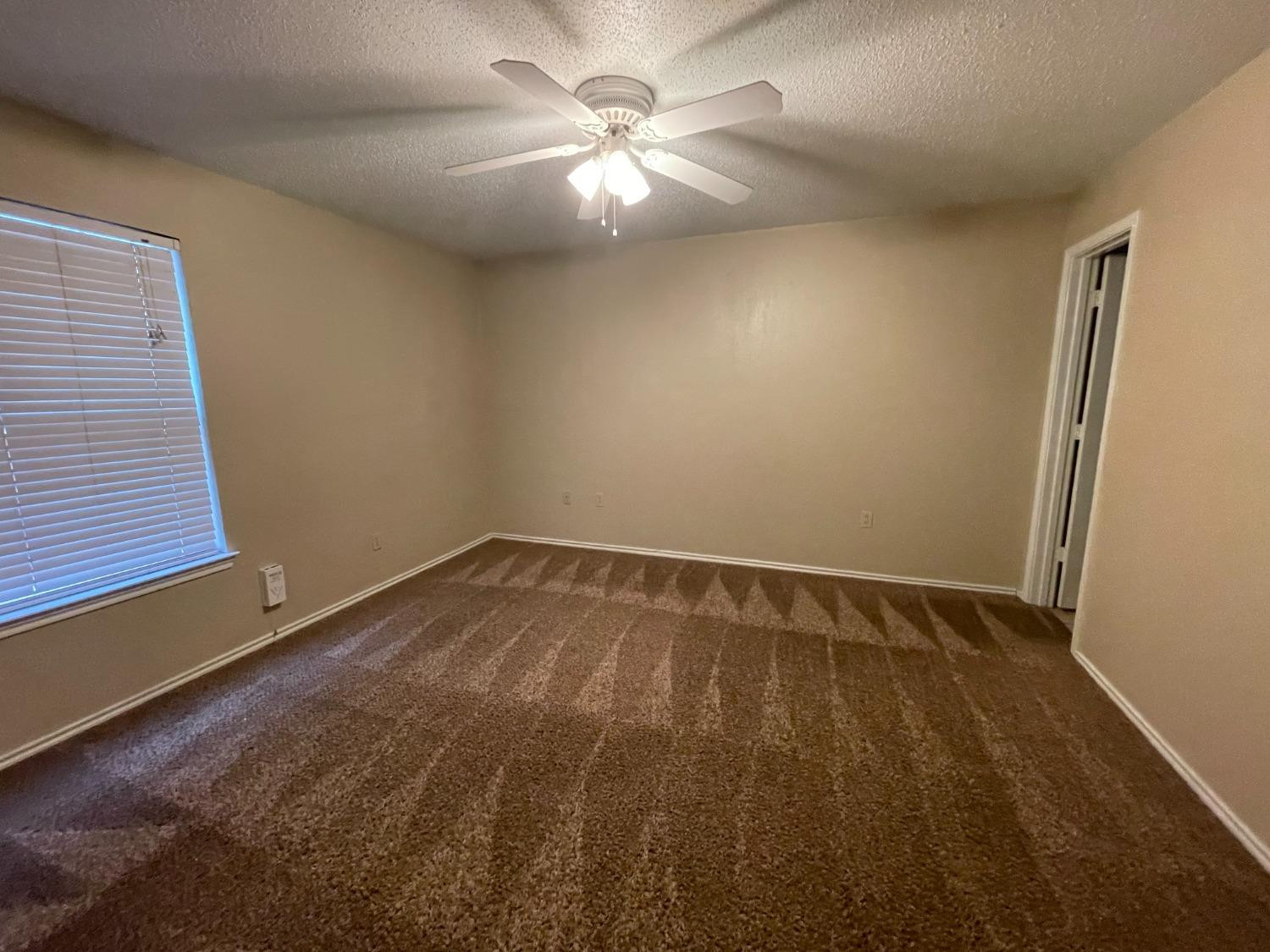 5827 6th Street, Unit A Lubbock, TX 79416 - Photo 9 of 10 wooden floor in an empty room with a window