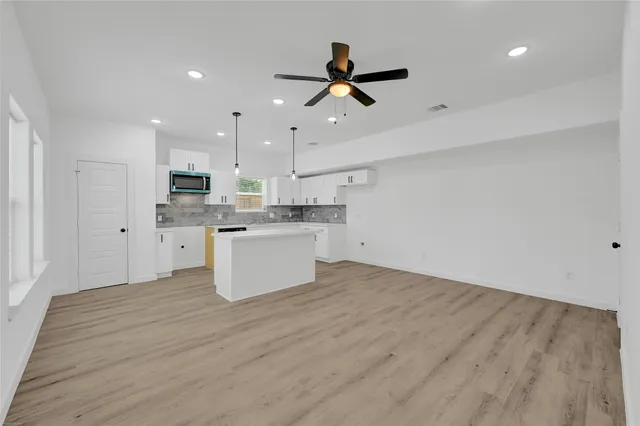 a view of kitchen with stove microwave and white cabinets