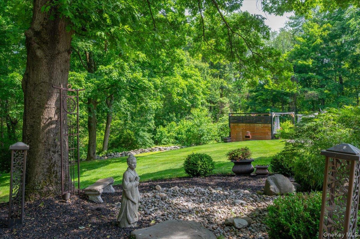 13 Jacks Pond Road Newburgh, NY 12550 - Photo 38 of 44 Generous lawn area framed by mature trees, complete with a stone bench, river rock accents, and a peaceful, tranquil setting.