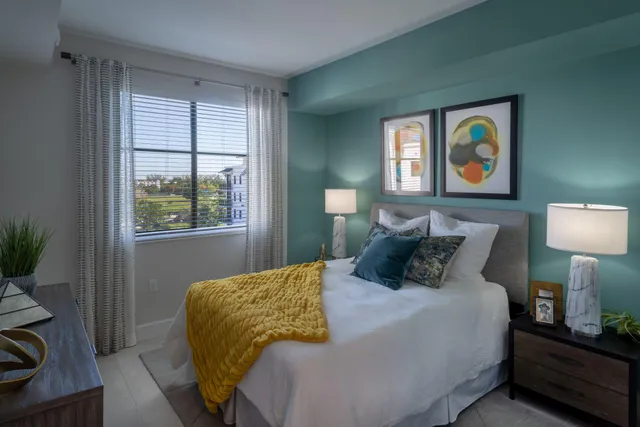 a bedroom with a bed and a lamp on dresser