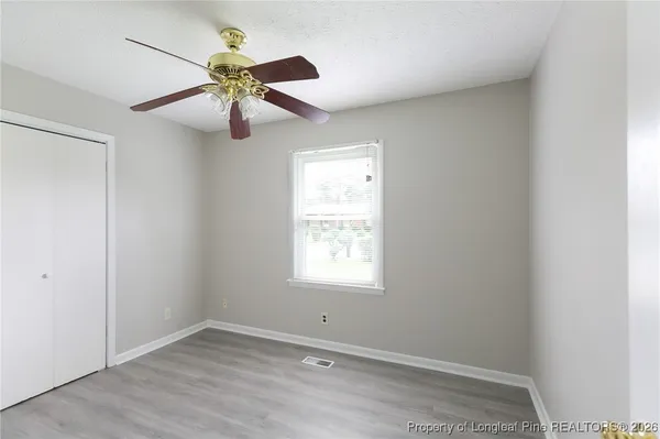 an empty room with window and chandelier fan