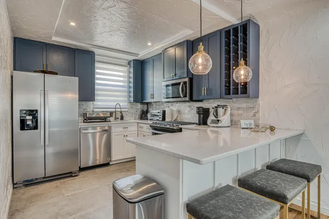 a kitchen with stainless steel appliances granite countertop a stove a sink and a refrigerator