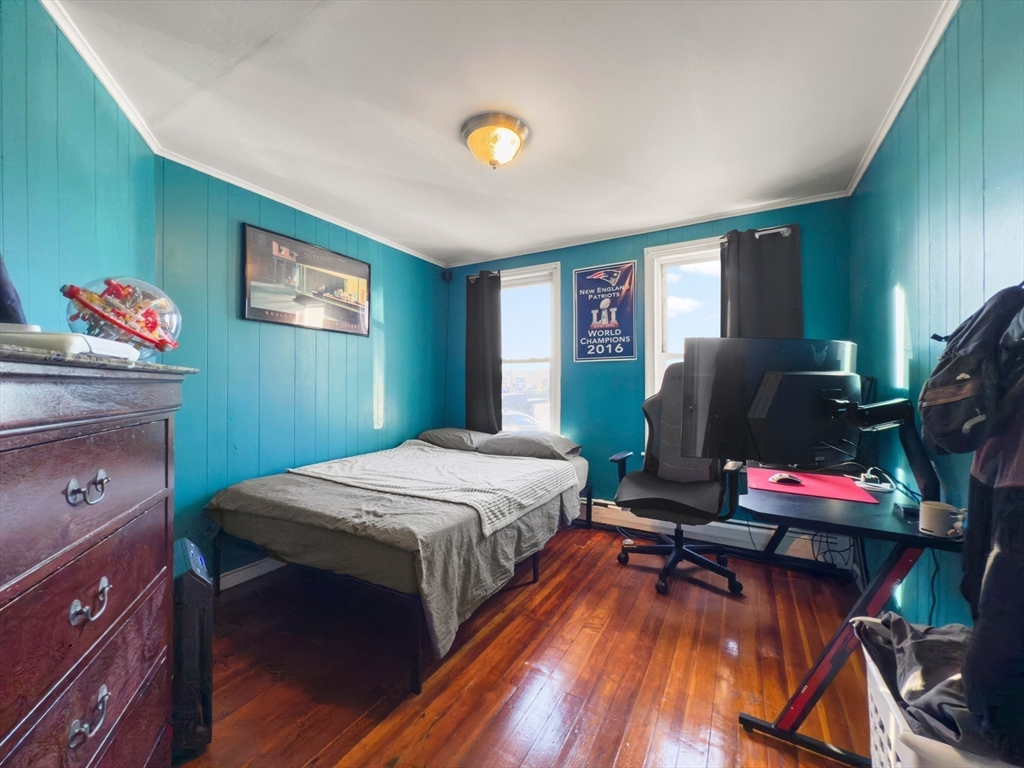 339-341 Lawrence Street Lawrence, MA 01841 - Photo 11 of 20 a bedroom with a bed and wooden floor