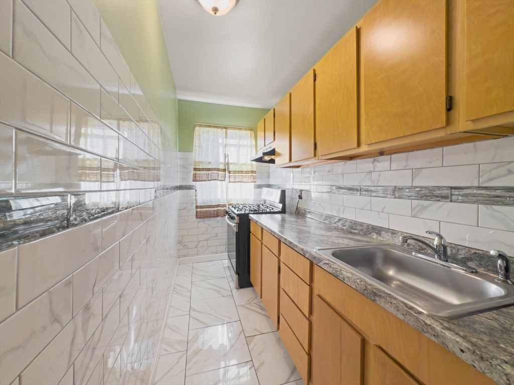 339-341 Lawrence Street Lawrence, MA 01841 - Photo 6 of 20 a kitchen with stainless steel appliances granite countertop a sink and cabinets