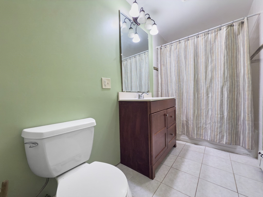 339-341 Lawrence Street Lawrence, MA 01841 - Photo 8 of 20 a bathroom with a toilet a sink and mirror