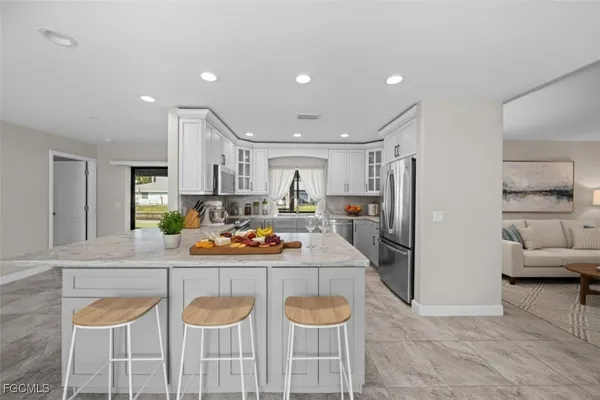 a kitchen with granite countertop white cabinets and stainless steel appliances