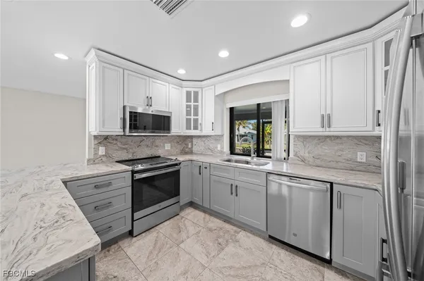a kitchen with stainless steel appliances granite countertop a refrigerator sink and cabinets