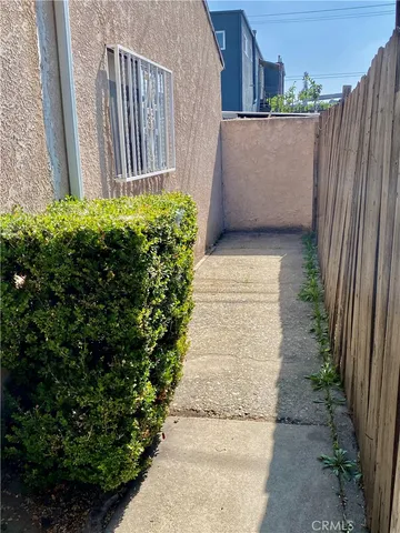 a view of a pathway of a house with wooden fence
