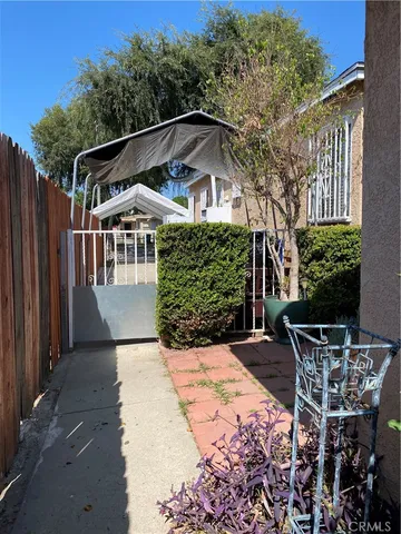 a patio with table and chairs and potted plants
