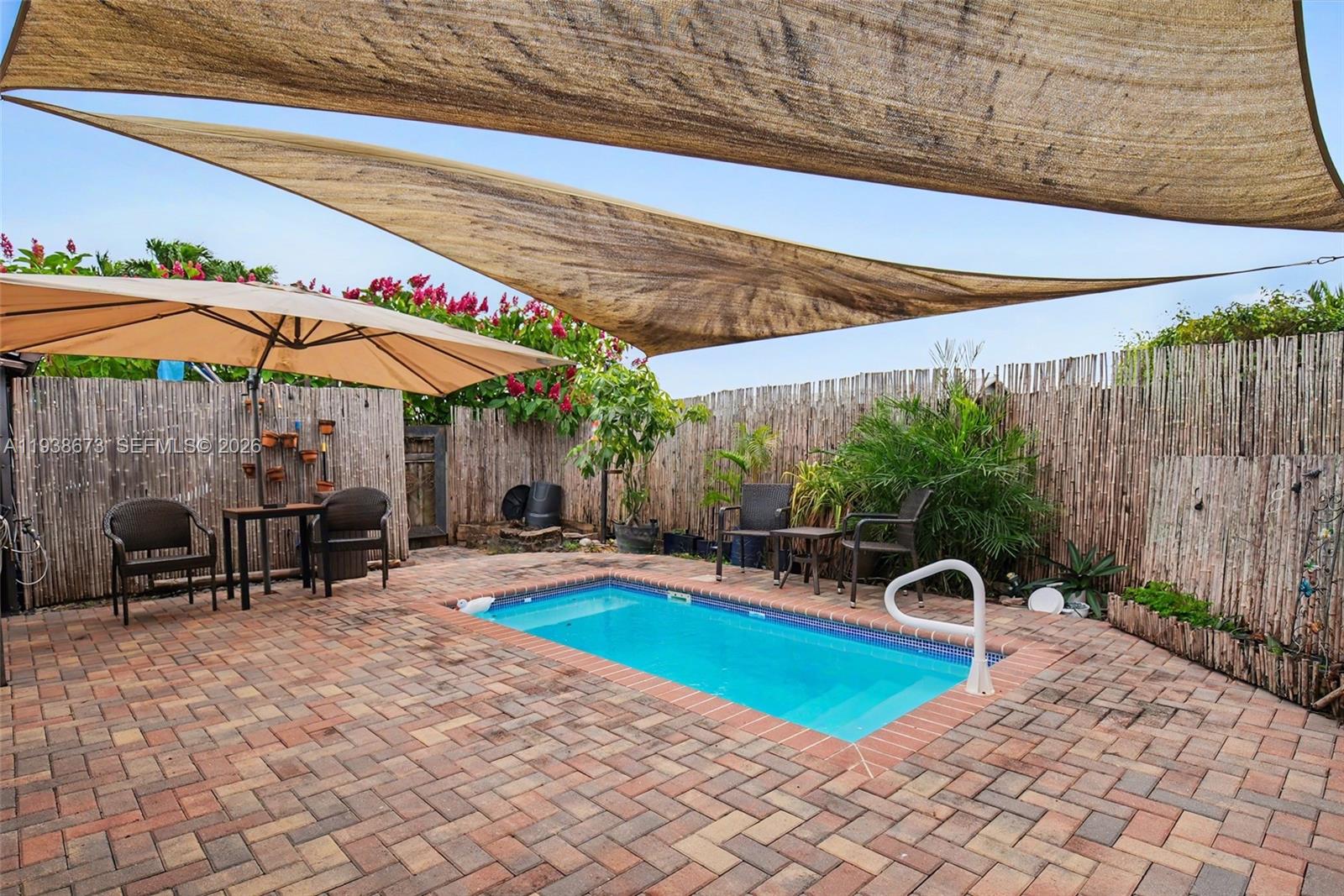 13574 Southwest 49th Lane Miami, FL 33175 - Photo 29 of 36 a patio with a table and chairs under an umbrella