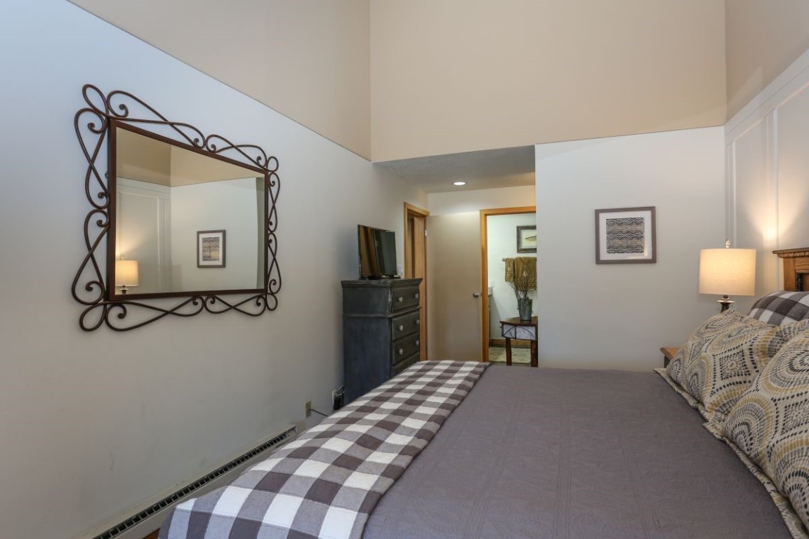 21680 Highway 6, Unit 2058 Keystone, CO 80435 - Photo 13 of 33 a bedroom with a bed and a mirror