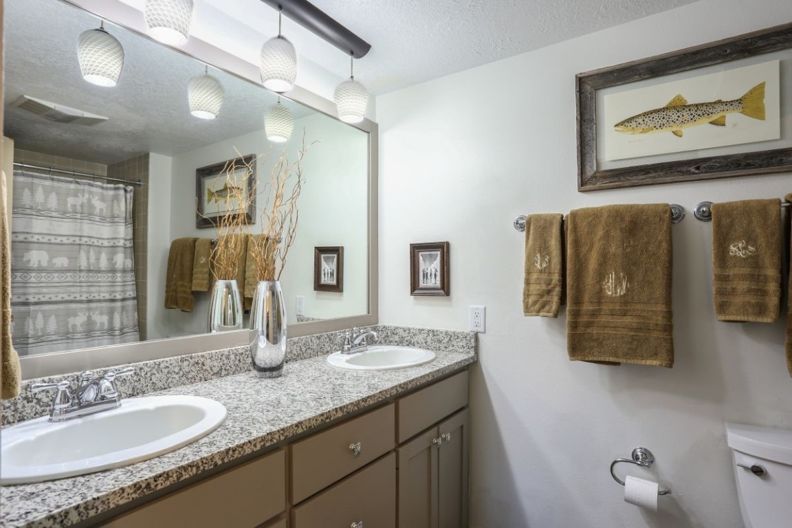 21680 Highway 6, Unit 2058 Keystone, CO 80435 - Photo 15 of 33 a bathroom with a granite countertop sink a mirror and shower