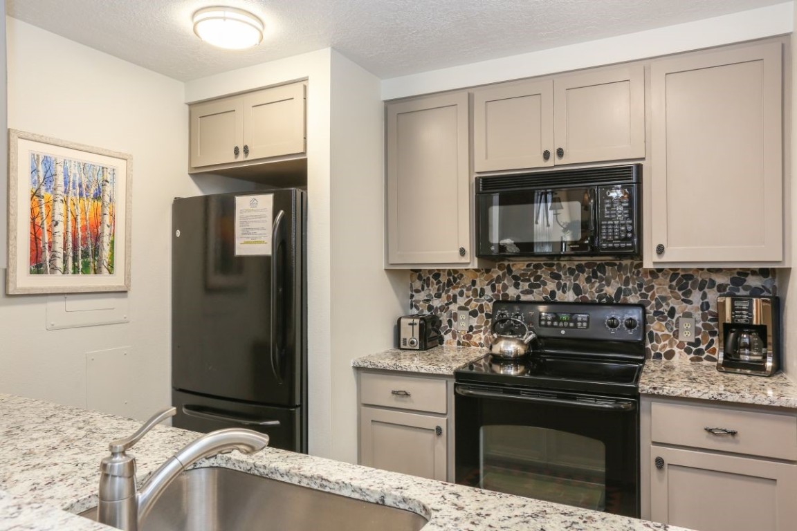 21680 Highway 6, Unit 2058 Keystone, CO 80435 - Photo 7 of 33 a kitchen with granite countertop cabinets stainless steel appliances and wooden cabinets