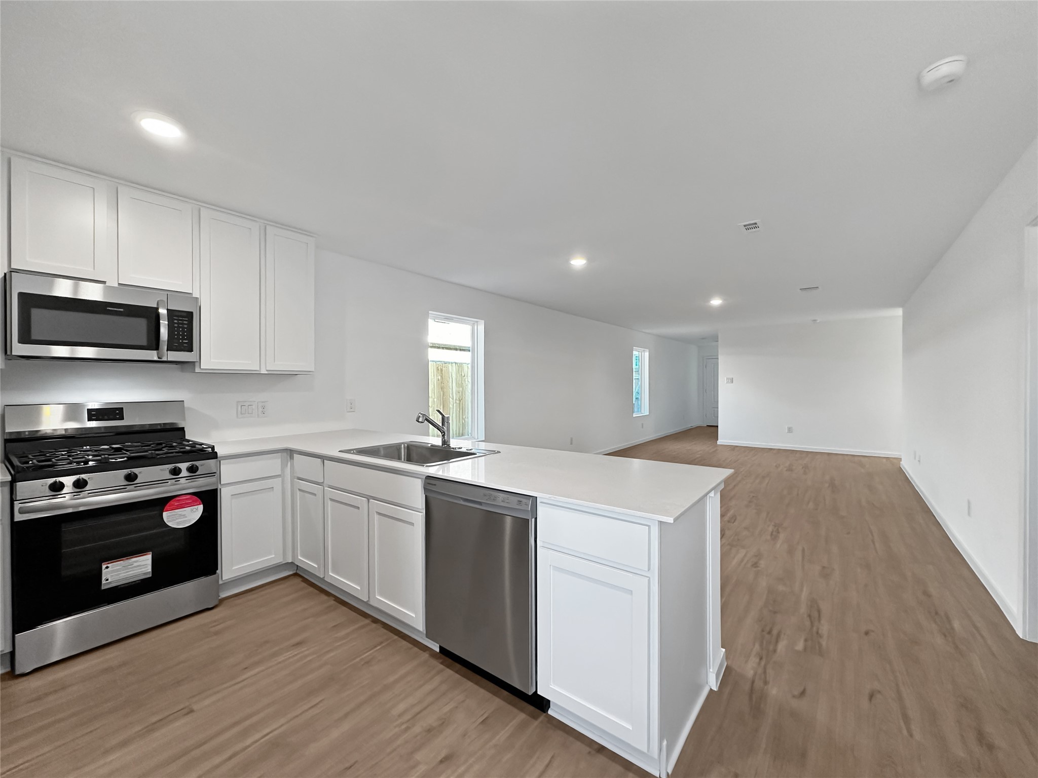1715 Windrose Bend Angleton, TX 77515 - Photo 7 of 26 a kitchen with a stove a sink and a microwave
