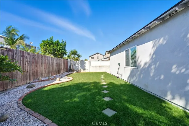 a view of backyard with wooden fence and large trees
