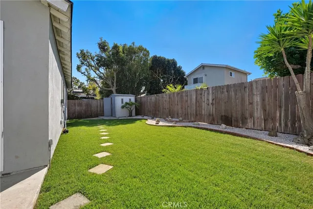 a view of a backyard with a small yard and wooden fence