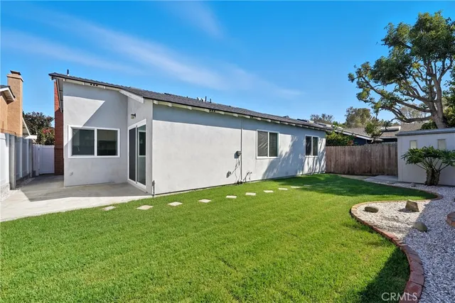 a view of a house with backyard and a tree
