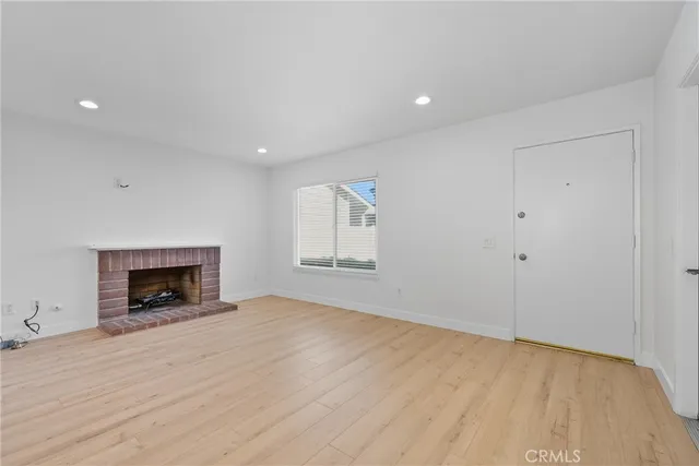 an empty room with a fireplace and window