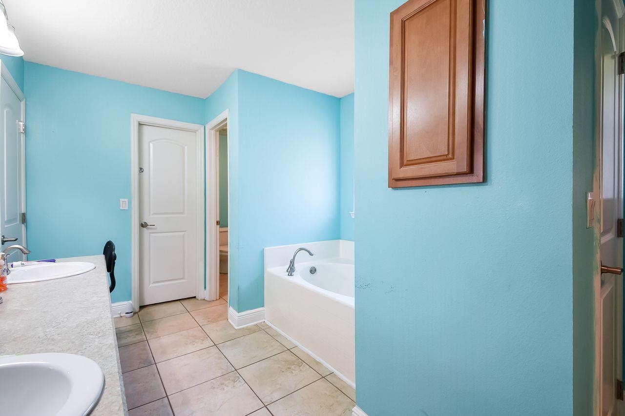 46 Riddle Drive Palm Coast, FL 32164 - Photo 8 of 20 a bathroom with a sink a toilet and shower