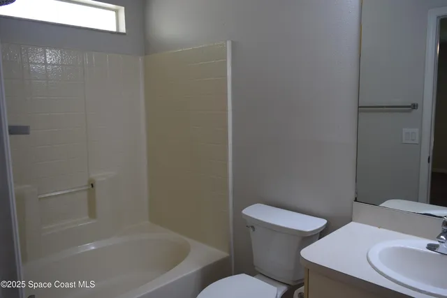 a white toilet sitting next to a bath tub