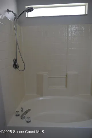 a view of a room with wooden floor and mirror