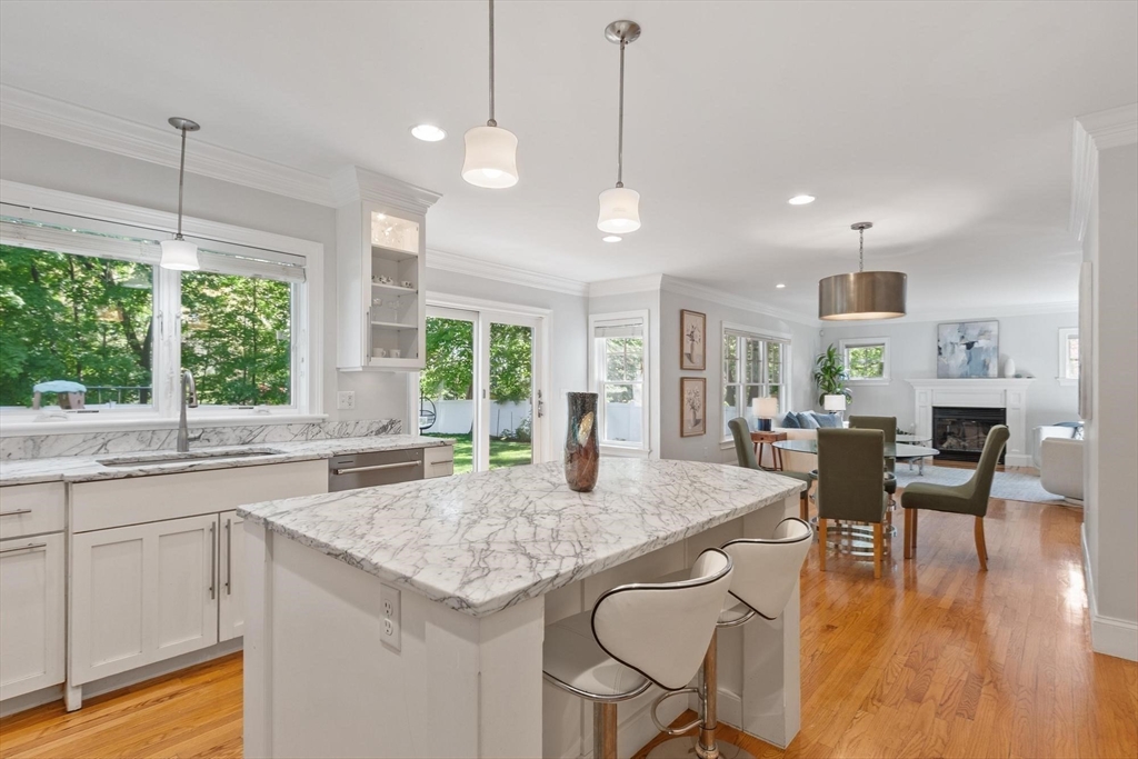 56 Old Marlboro Road Concord, MA 01742 - Photo 4 of 34 a open kitchen with granite countertop a stove a sink a dining table and chairs with wooden floor