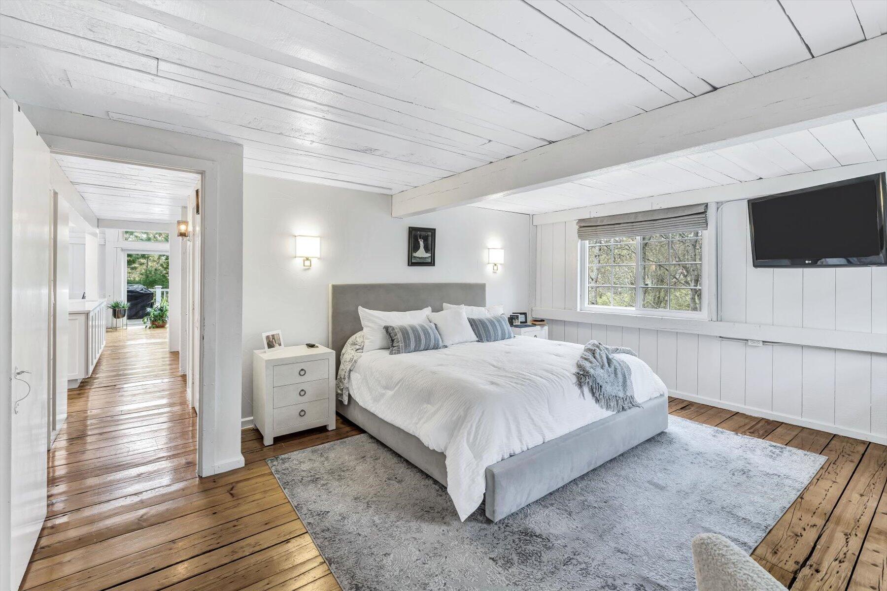 15 Greensward Road Mashpee, MA 02649 - Photo 13 of 27 a spacious bedroom with a bed a flat screen tv and windows