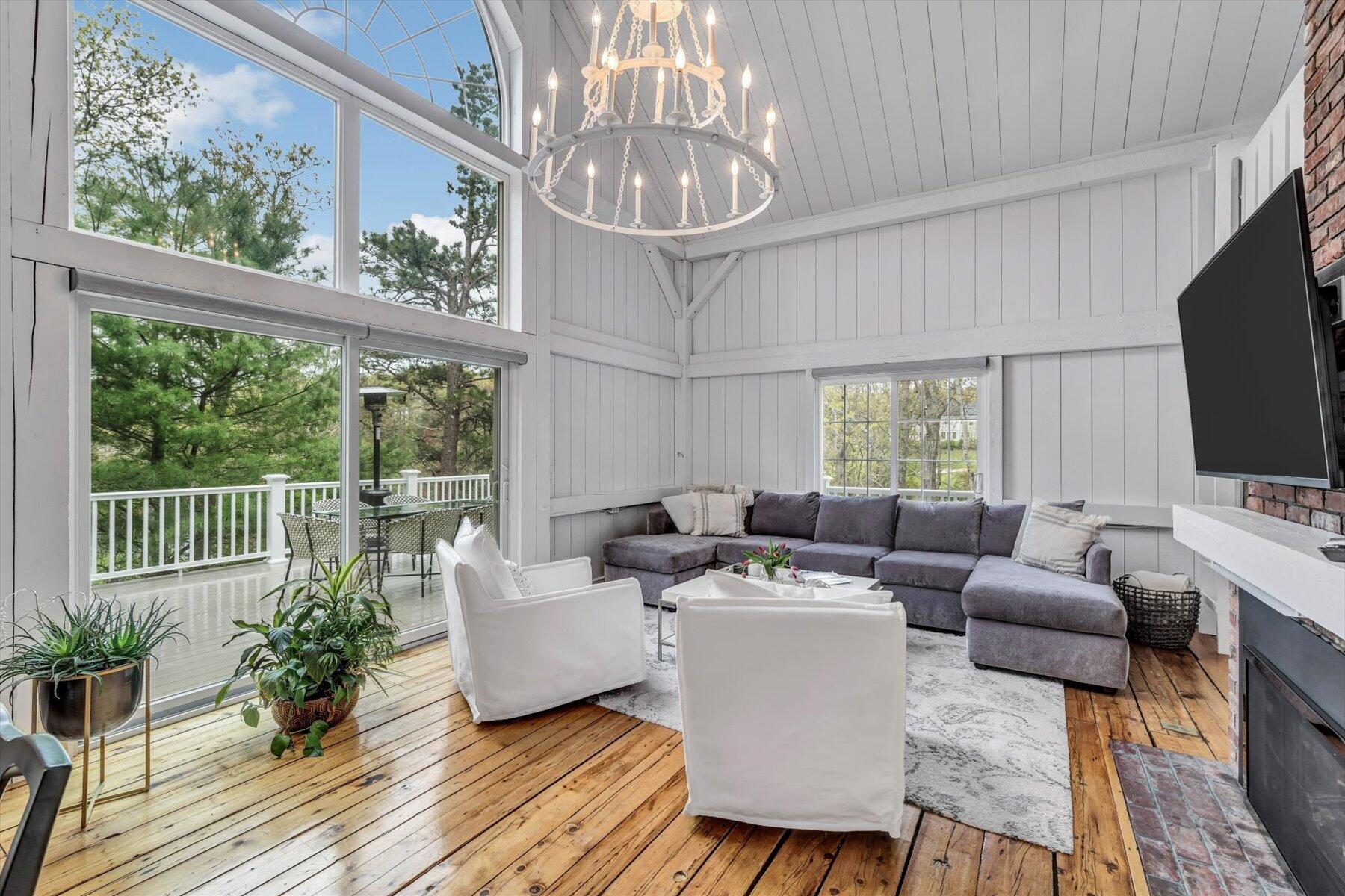 15 Greensward Road Mashpee, MA 02649 - Photo 6 of 27 a living room with furniture a chandelier and a flat screen tv