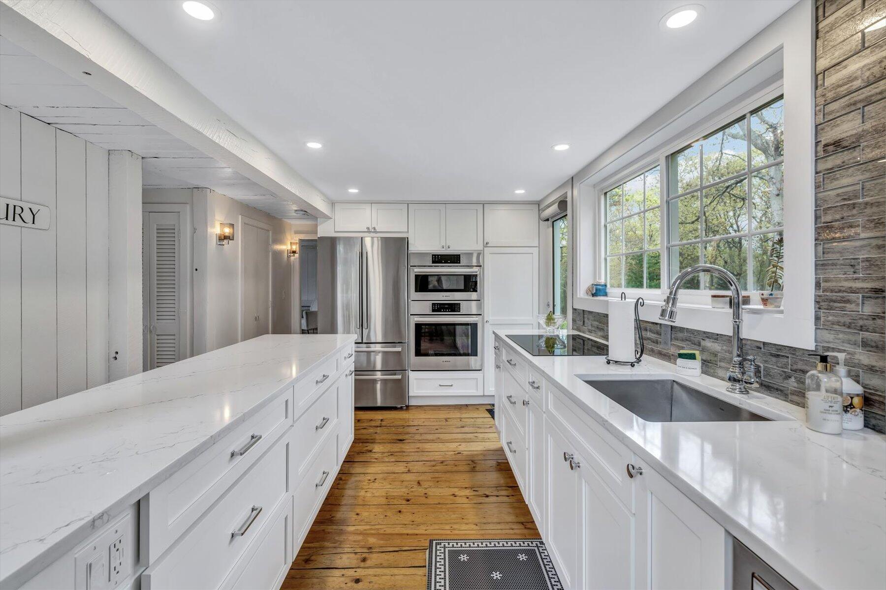 15 Greensward Road Mashpee, MA 02649 - Photo 9 of 27 a large kitchen with kitchen island a large counter top a sink stainless steel appliances and cabinets