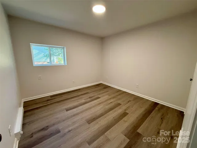 a view of a room with wooden floor and white walls