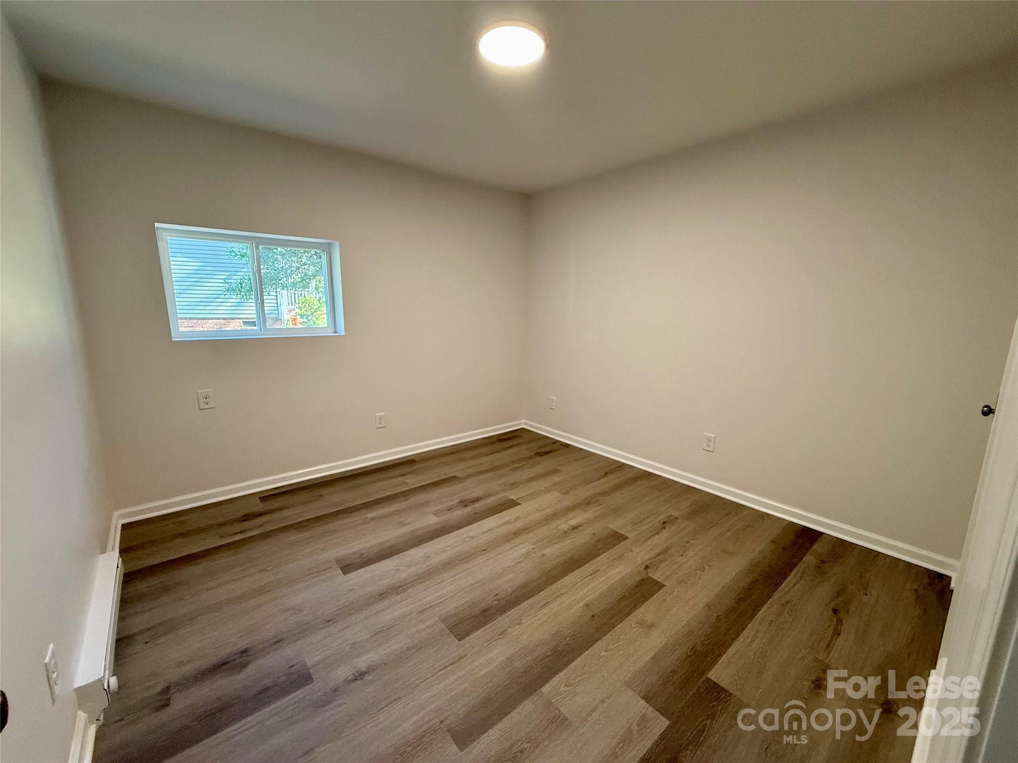 1902 West 5th Avenue, Unit B Gastonia, NC 28052 - Photo 13 of 25 a view of a room with wooden floor and white walls