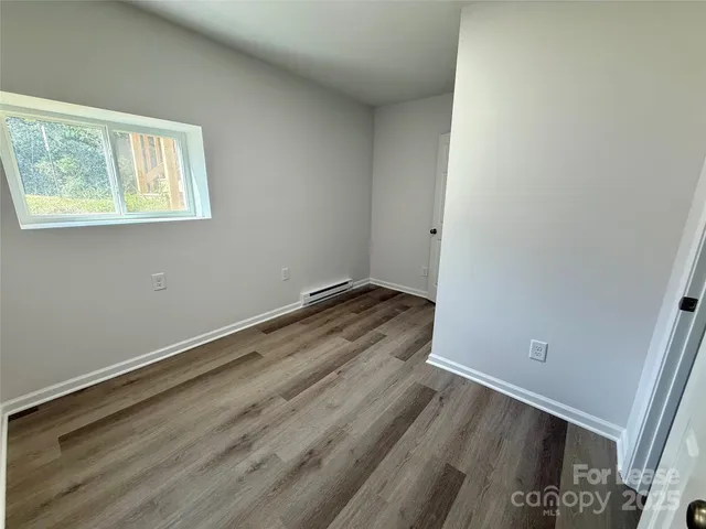 a view of a room with wooden floor and white walls