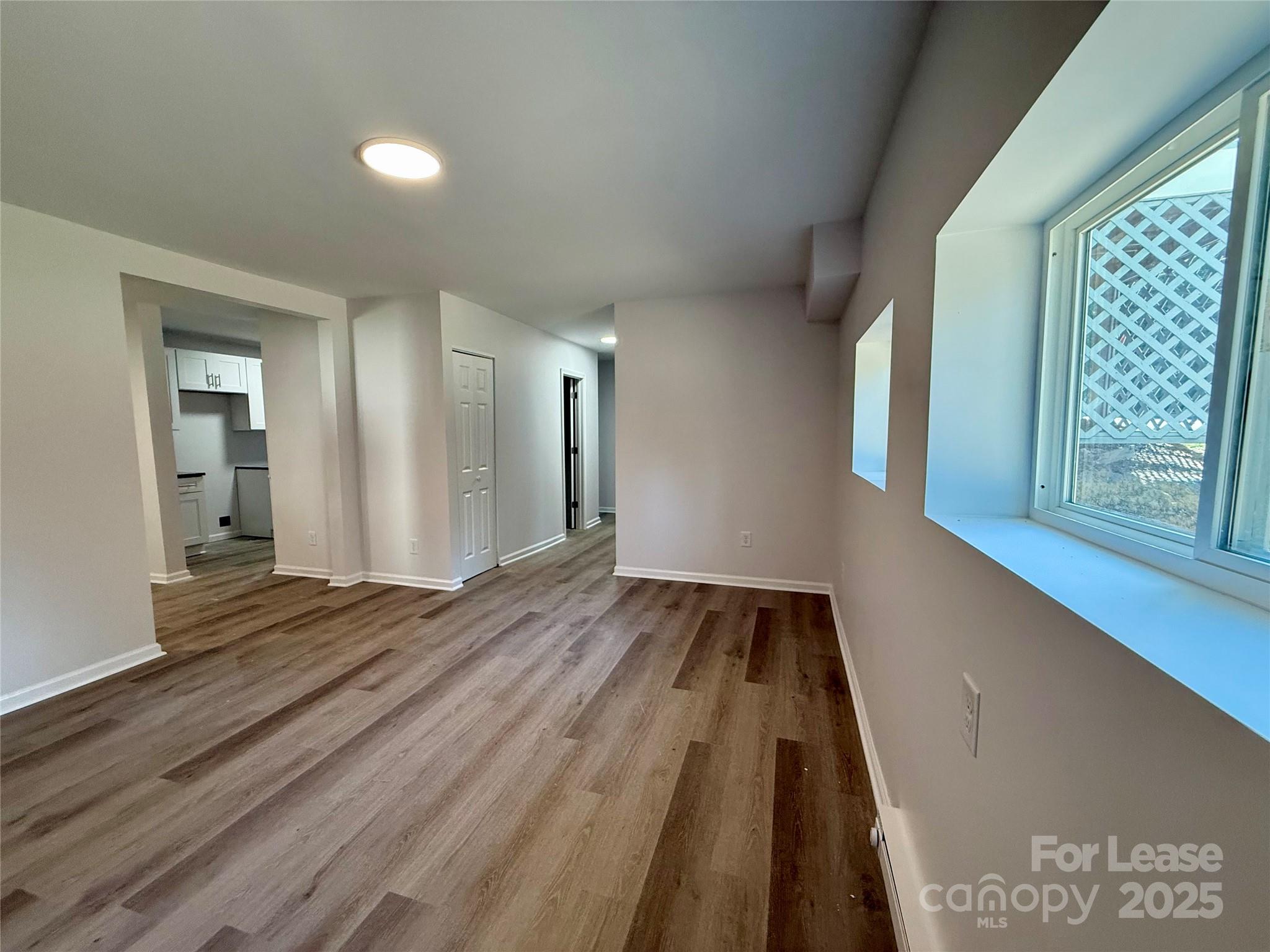 1902 West 5th Avenue, Unit B Gastonia, NC 28052 - Photo 7 of 25 a view of an empty room with wooden floor and a window