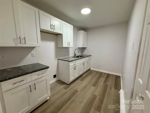 a kitchen with granite countertop white cabinets and white appliances