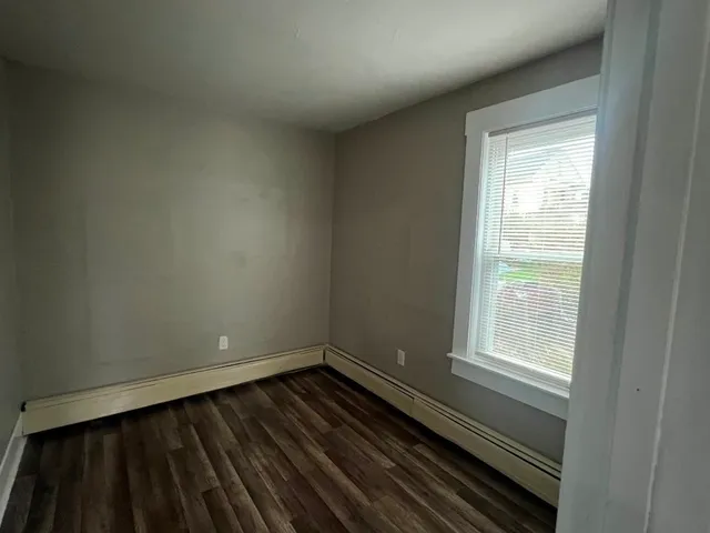 a view of a room with wooden floor and a window