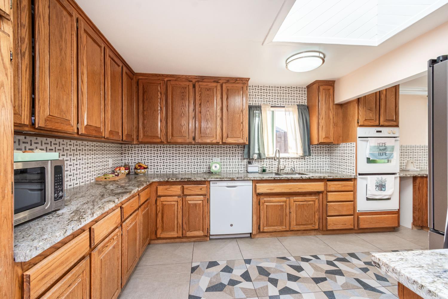 6851 Aleta Way Sacramento, CA 95842 - Photo 22 of 45 a kitchen with stainless steel appliances granite countertop a sink stove and cabinets