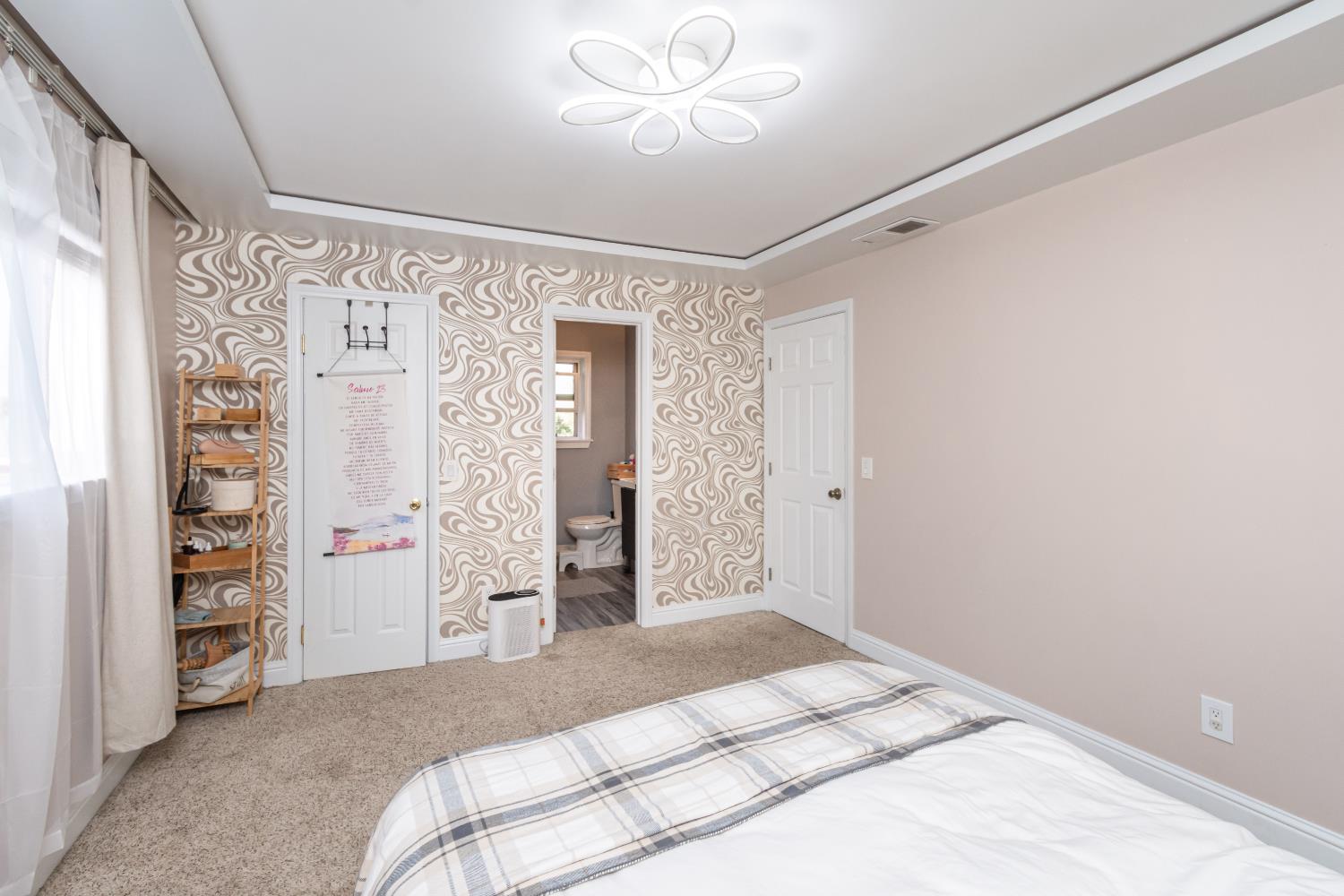 6851 Aleta Way Sacramento, CA 95842 - Photo 31 of 45 a spacious bedroom with a large bed and a chandelier