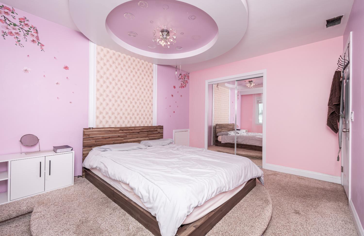 6851 Aleta Way Sacramento, CA 95842 - Photo 35 of 45 a bedroom with a bed and a chandelier