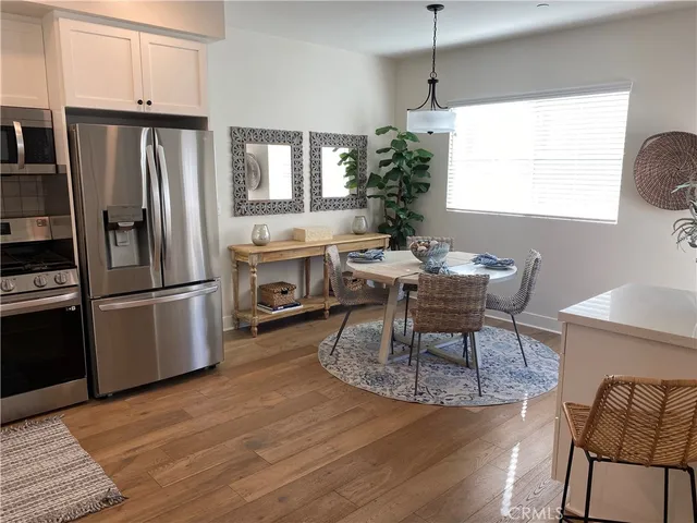 a dining room with furniture a chandelier and wooden floor