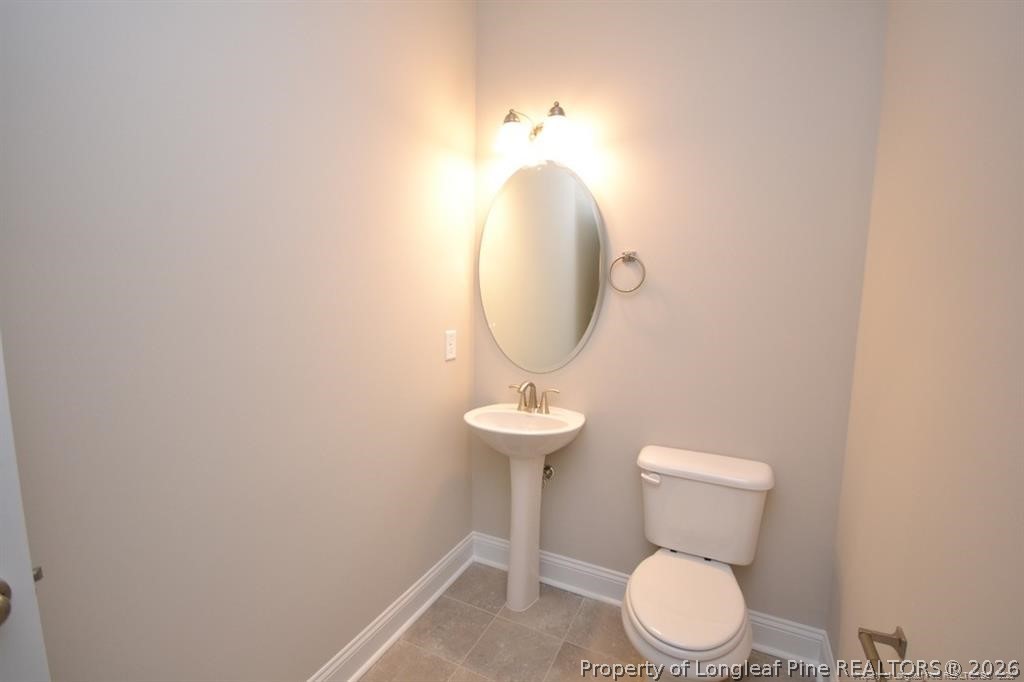 5219 Riva Ridge Lane Hope Mills, NC 28348 - Photo 14 of 27 a bathroom with a toilet a sink and a mirror