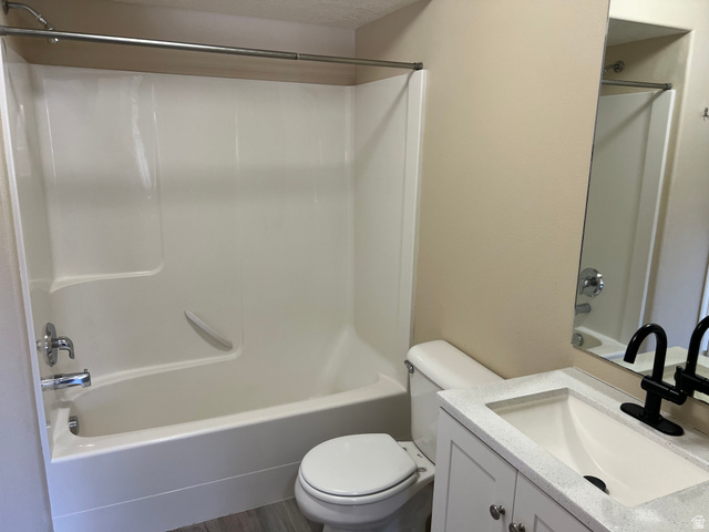 8198 North Cedar Springs Road, Unit T6 Eagle Mountain, UT 84005 - Photo 7 of 13 Full bathroom featuring vanity, washtub / shower combination, and dark wood-type flooring