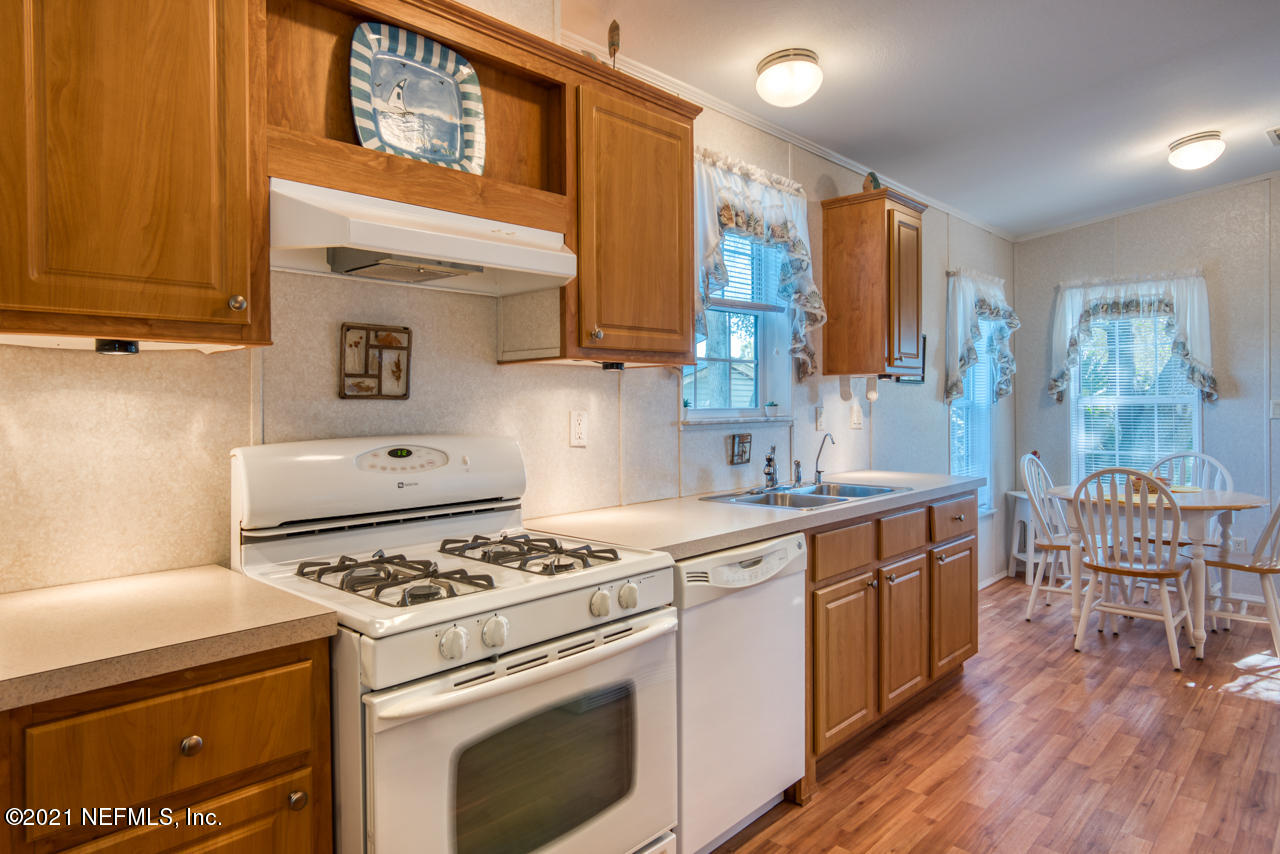 279 Pizarro Road St. Augustine, FL 32080 - Photo 13 of 34 a kitchen with a stove a sink and wooden cabinets