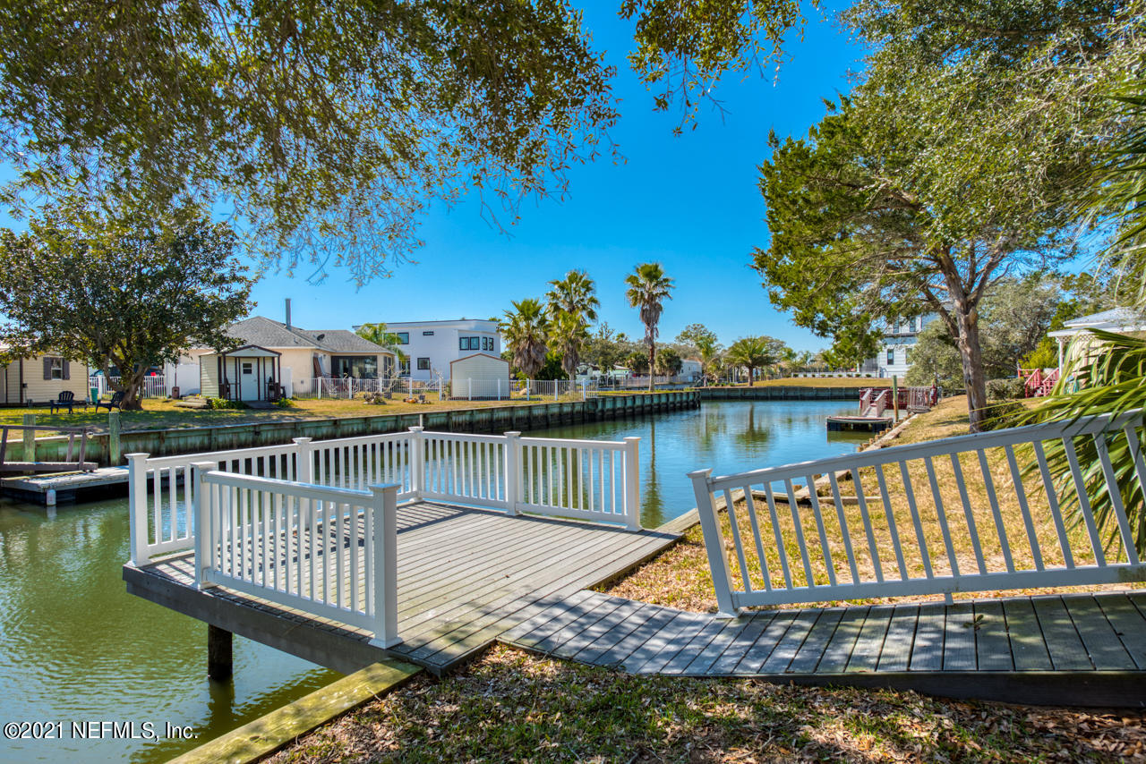 279 Pizarro Road St. Augustine, FL 32080 - Photo 2 of 34 a view of a roof deck with two large trees and wooden fence