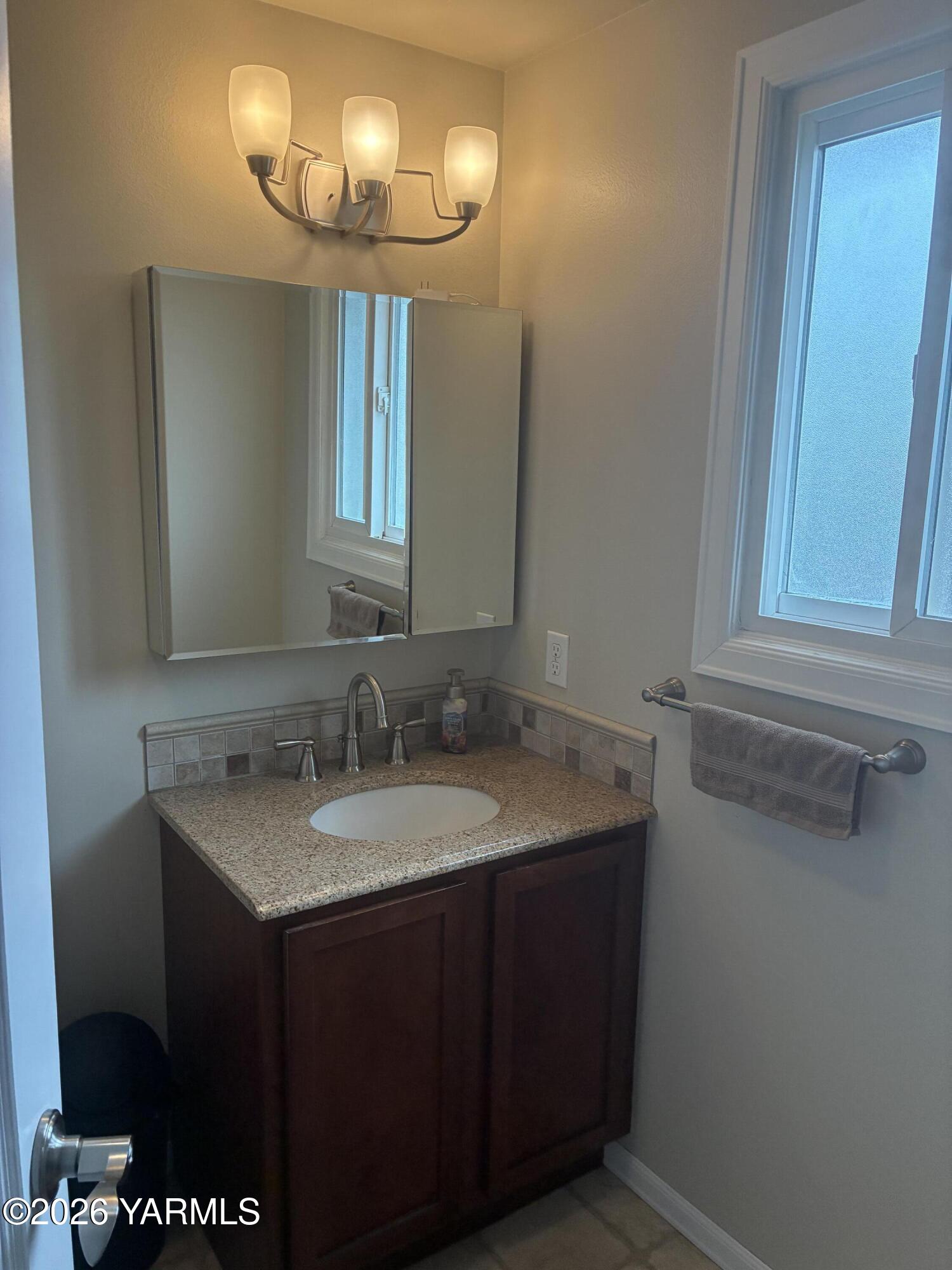 303 Ave G Grandview, WA 98930 - Photo 18 of 23 a bathroom with a granite countertop sink and a mirror