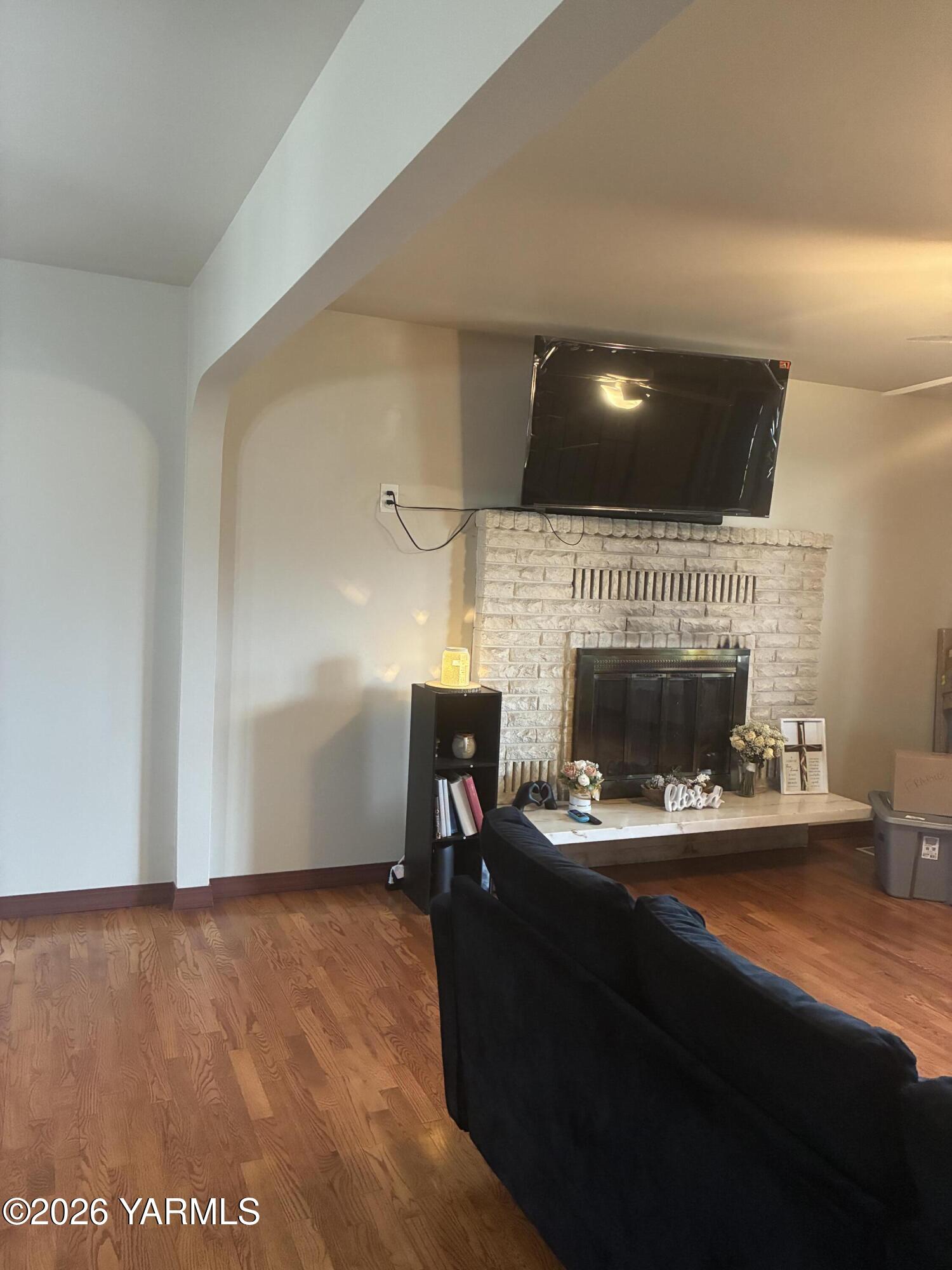 303 Ave G Grandview, WA 98930 - Photo 6 of 23 a living room with furniture a flat screen tv and a fireplace